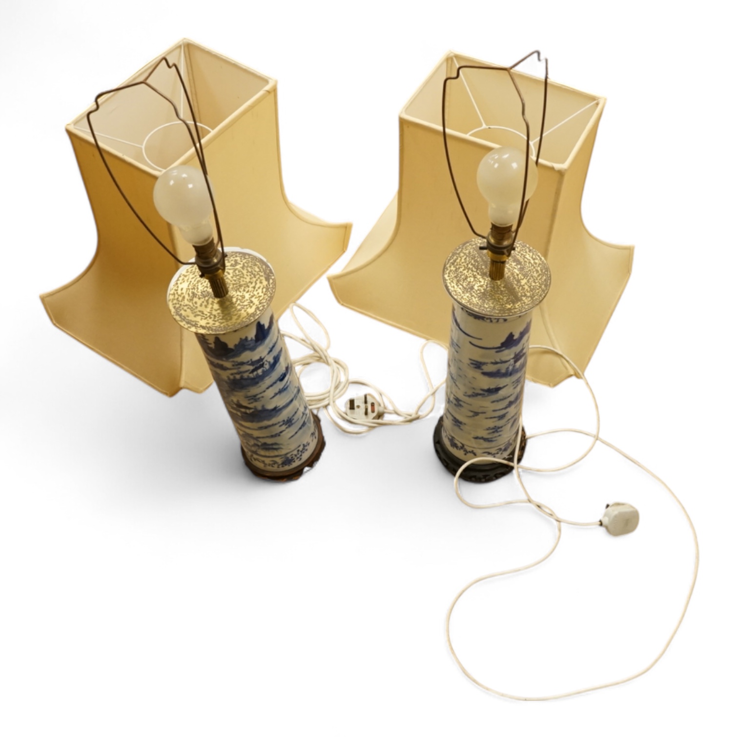 A pair of tall Chinese blue and white ‘landscape’ sleeve vases, c.1900, drilled and mounted as lamps with shades, 39cm high excluding the fitting